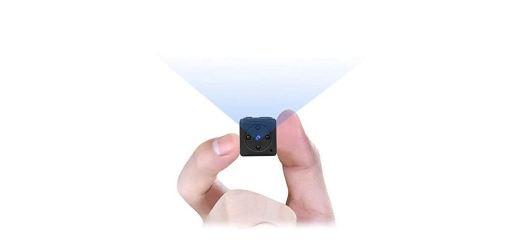 Spy Camera 1 A person holds a small, cube-shaped camera with a blue light, projecting a beam, illustrating its compactness and portability.